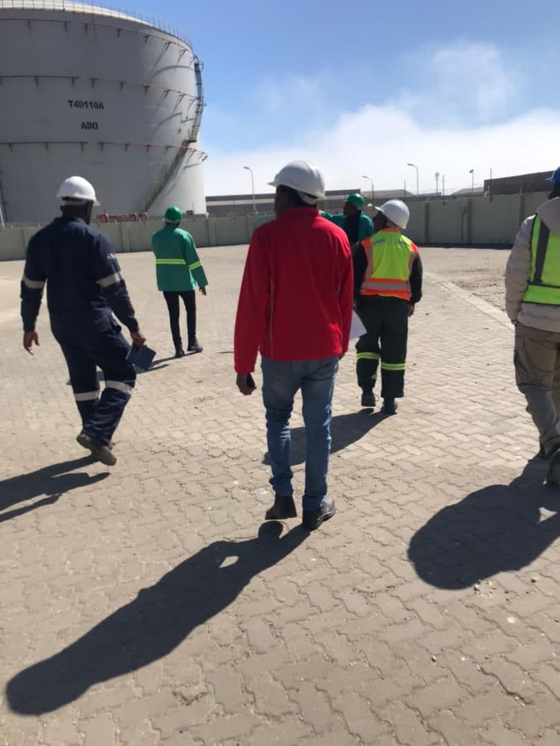 People walking beside industrial storage infrastructure